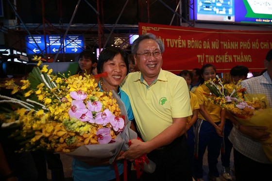 Ông Mai Bá Hùng trao hoa chúc mừng HLV Kim Chi và toàn đội tại sân bay Tây Sơn Nhất tối 5-10. Ảnh: DŨNG PHƯƠNG