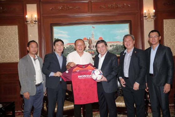 Chủ tịch UBND TPHCM Nguyễn Thành Phong nhận món quà lưu niệm là áo thi đấu và trái bóng từ HLV Park Hang-seo. Ảnh: DŨNG PHƯƠNG