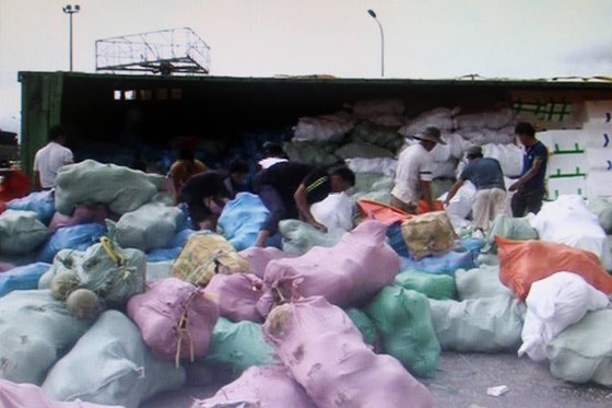 Người dân giúp thu gom hàng tấn trái cây sau tai nạn lật xe container ảnh 1
