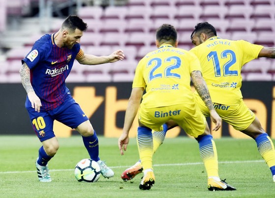 Messi (đỏ xanh) gieo nỗi kinh hoàng lên hàng thủ Las Palmas. Ảnh: Getty Images