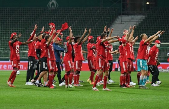 Bayern hướng về khán đài trống chia sẻ vinh quang với người hâm mộ. Ảnh: Getty Images
