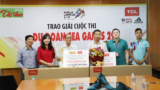 Phó Tổng Biên tập Báo SGGP Nguyễn Nhật và bà Summer Gao Ya, Tổng Giám đốc TCL Việt Nam (thứ nhất và thứ nhì bên trái), trao 2 Tivi TCL C2 55 inch tặng bạn đọc trúng giải Nhất. Ảnh: HOÀNG HÙNG
