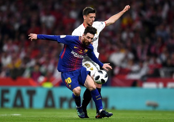 Lio Messi đi bóng qua hậu vệ Sevilla
