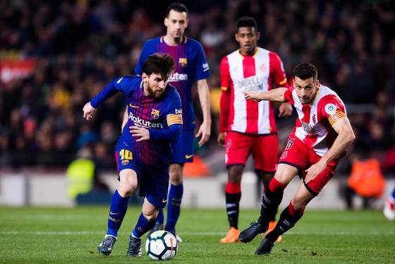 Lionel Messi (trái, Barcelona) đi bóng trước hậu vệ Ginora