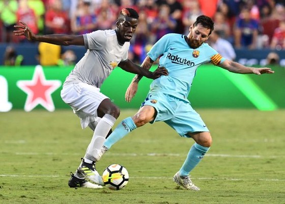 Lionel Messi (phải) tranh bóng với Paul Pogba (Man United)