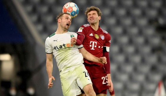 Thomas Muller tranh bóng với hậu vệ Gladbach