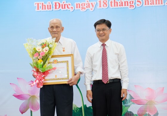 Phó Bí thư Thường trực Thành ủy TPHCM Trần Lưu Quang trao Huy hiệu Đảng cho đảng viên cao tuổi Đảng ảnh 1
