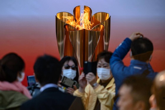 Nhiều du khách đeo khẩu trang vẫn đến thăm đài lửa Olympic Tokyo 