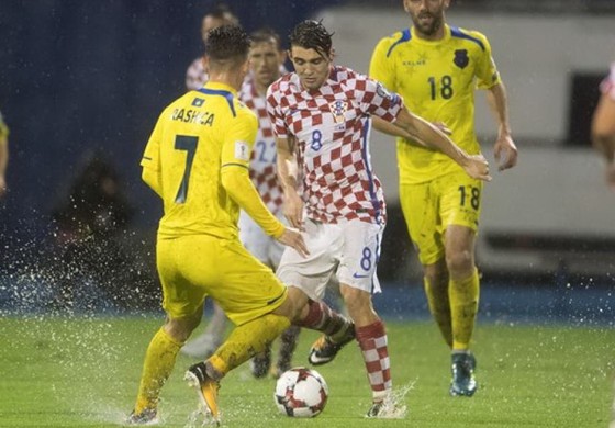 Matteo Kovacic (8, Croatia) đi bóng giữa hàng thủ Kosovo trong "trận thủy chiến" ở Zagreb. Ảnh: Total Croatia News