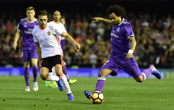 Hậu vệ Marcelo (phải, Real Madrid) sút bóng trước Munir El Haddadi (Valencia). Ảnh: Getty Images.
