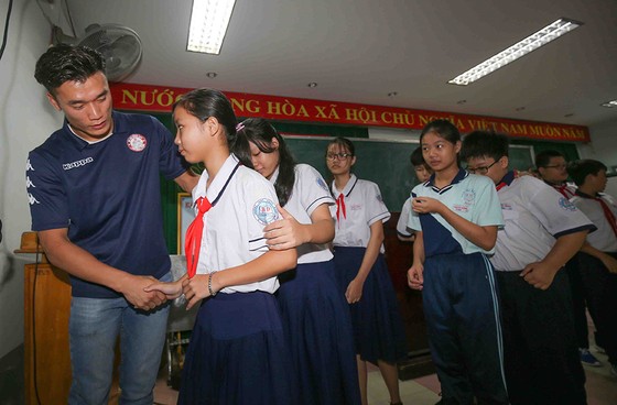 Thủ môn Bùi Tiến Dũng và đội trưởng Văn Thuận sẻ chia  với học sinh gặp tai nạn trường THCS Bạch Đằng  ảnh 4