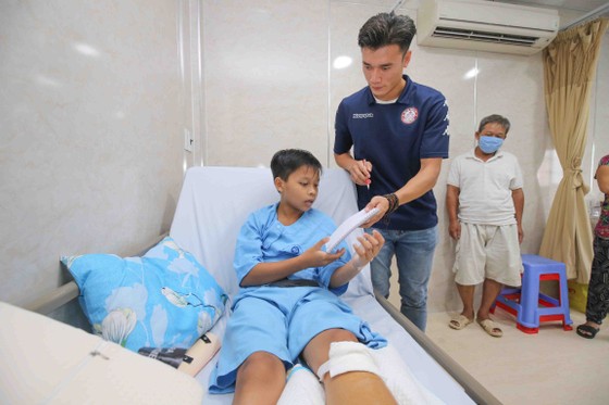 Thủ môn Bùi Tiến Dũng và đội trưởng Văn Thuận sẻ chia  với học sinh gặp tai nạn trường THCS Bạch Đằng  ảnh 8