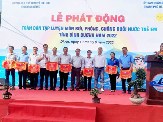 Ban Tổ chức và đại biểu trao cờ lưu niệm cho các đơn vị về tham dự Lễ phát động toàn dân tập luyện môn bơi, phòng, chống đuối nước năm 2022