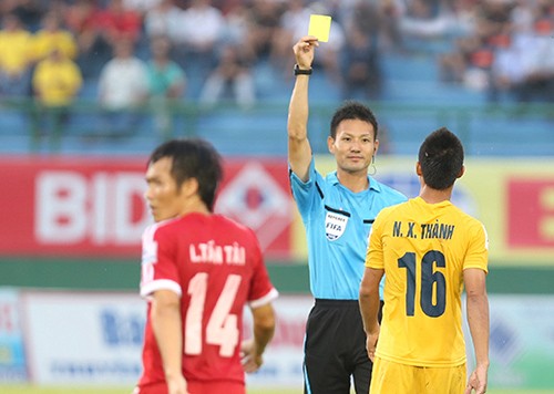 Trọng tài Sato Ryuji rút thẻ vàng với cầu thủ Thanh Hóa tại V-League 2014. Ảnh: QUANG LIÊM
