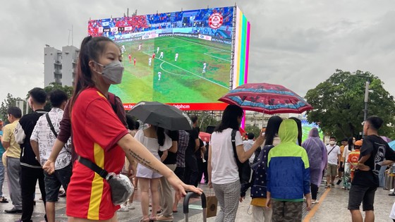 Người hâm mộ TPHCM đội mưa, cổ vũ đội tuyển U23 Việt Nam tại phố đi bộ Nguyễn Huệ ảnh 3