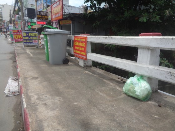 Vứt rác tràn lan trên cầu dù có bảng cấm và thùng rác ảnh 2