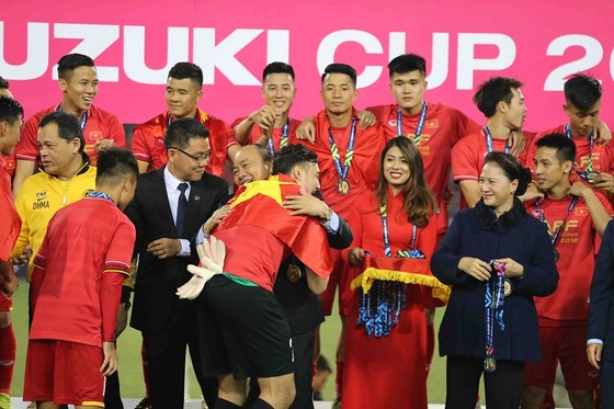 Thủ tướng Nguyễn Xuân Phúc chúc mừng từng thành viên của đội tuyển Việt Nam trên bục trao Cúp vô địch. Ảnh: DŨNG PHƯƠNG
