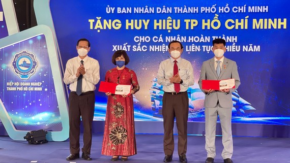 Bí thư Thành ủy TPHCM Nguyễn Văn Nên và Chủ tịch UBND TPHCM Phan Văn Mãi  tặng Huy hiệu TPHCM cho các doanh nhân tiêu biểu. Ảnh: HOÀNG HÙNG