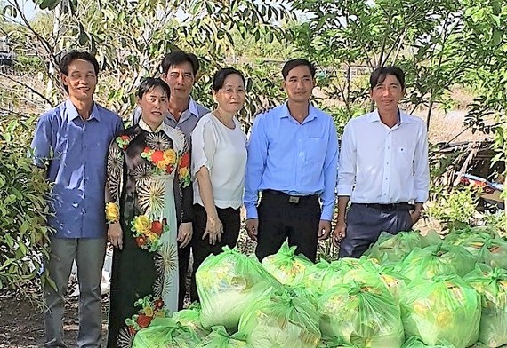 Ông Trần Tấn Nhanh và đại diện địa phương trao quà nhu yếu phẩm cho bà con