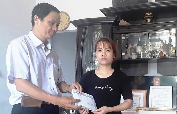 Đại diện Báo Sài Gòn Giải Phóng trao tiền bạn đọc hỗ trợ gia đình "hiệp sĩ" Nam.