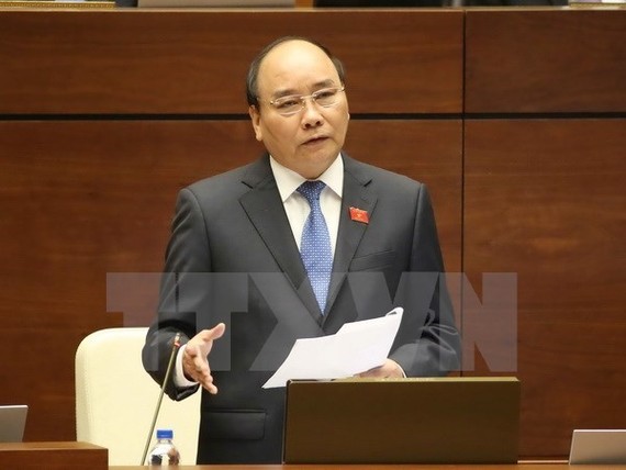 Prime Minister Nguyen Xuan Phuc answers questions at the second working session of the parliament (Photo: VNA)
