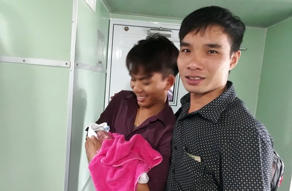 Nurse in ( black shirt) and young father Le MInh Nhut (Photo: SGGP)