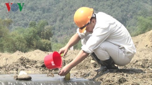 A worker collects water samples at the dam collapse site in the central province of Nghe An. (Photo: vov.vn)
