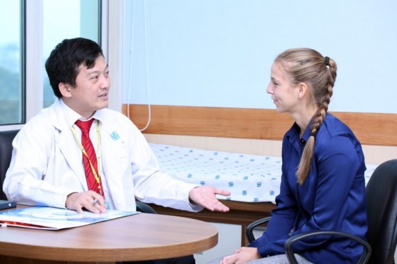 A doctor talks to a foreign woman about her symptoms (Photo: SGGP)