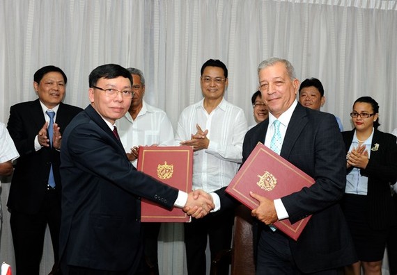 Representatives of the General Department of State Reserves of Vietnam and the Cuba Food Import-Export Corporation exchange the signed document on the handover of the 5,000 tonnes of rice (Photo: VNA)