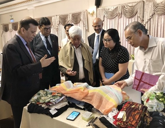 Dr. Bimal Mawandia (L), chairman of the Indian Silk Export Promotion Council, introduces Indian silk products to representatives of Vietnamese businesses at the Buyer-Seller Meet. (Photo: VNA)
