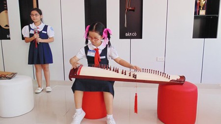 Students in Lac Long Quan Primary School (located in District 11) are performing a song with one traditional musical instrument