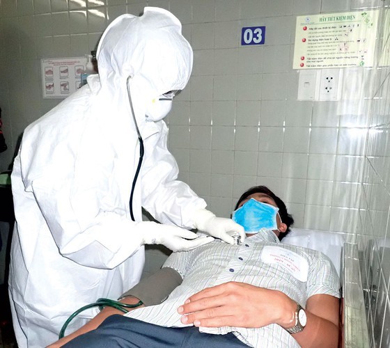 A medical worker examines a patient in a drill (Photo: SGGP)
