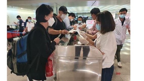 People from South Korea are filling health declararion forms at Tan Son Nhat airport(Photo: SGGP)