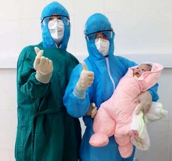Medical workers carry the newborn baby in the quarantine ward (Photo: SGGP)