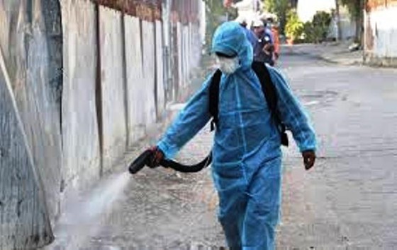 A medical worker sprays chemical to disinfect a residential quarter in Hai Phong City (Photo: SGGP)
