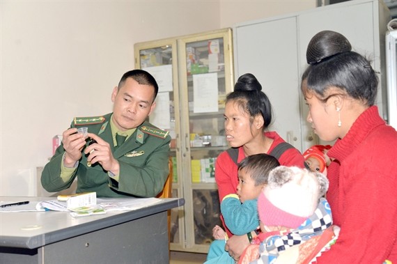 A military doctor from Phieng Pan border station in Sơn La Province instructs the local people on how to use medicine. — VNA/VNS Photo