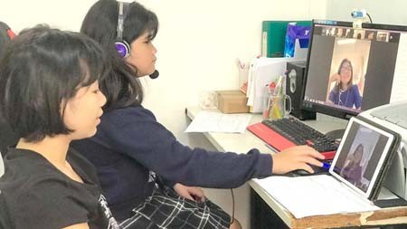 Two fifth graders in Hong Ngoc Primary School (located in Tan Phu District of HCMC) are taking part in their online learning session at home. (Photo: SGGP)
