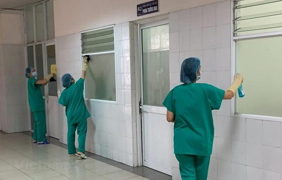 Medical workers clean COVID-19 patient rooms (Photo: VNA)