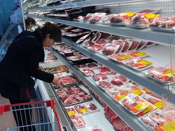A woman shops for pork in a supermarket in Hano. — VNA/VNS Photo