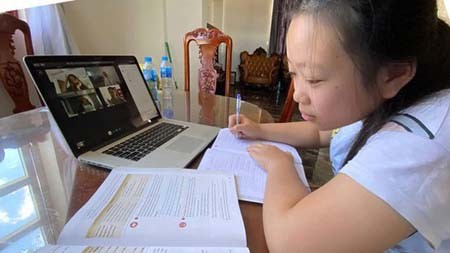 Pham Thuy Hien, a student of Quang Trung Secondary High School, is taking an online lesson at home. (Photo: SGGP)
