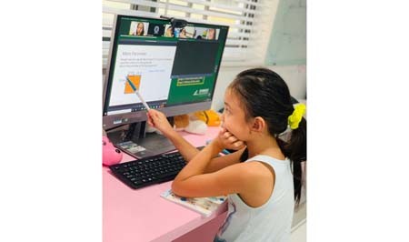 Second grader Pham Bao Thien Kim is taking part in an online lesson at home. (Phot: SGGP)
