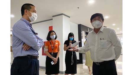 Chairman of HCMC People’s Committee Nguyen Thanh Phong is inspecting the safety status against Covid-19 in FPT Software Co. Ltd. (Photo: SGGP)