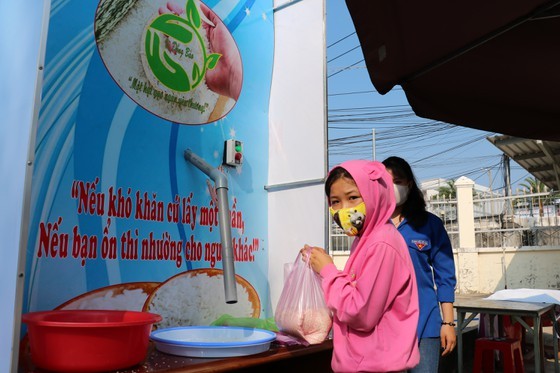 Poor people receive rice from the rice ATM in Ca Mau (Photo: SGGP)
