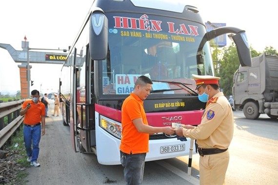 A traffic officer checks a driver's paperwork on National Highway 1A. (Photo: VNA)