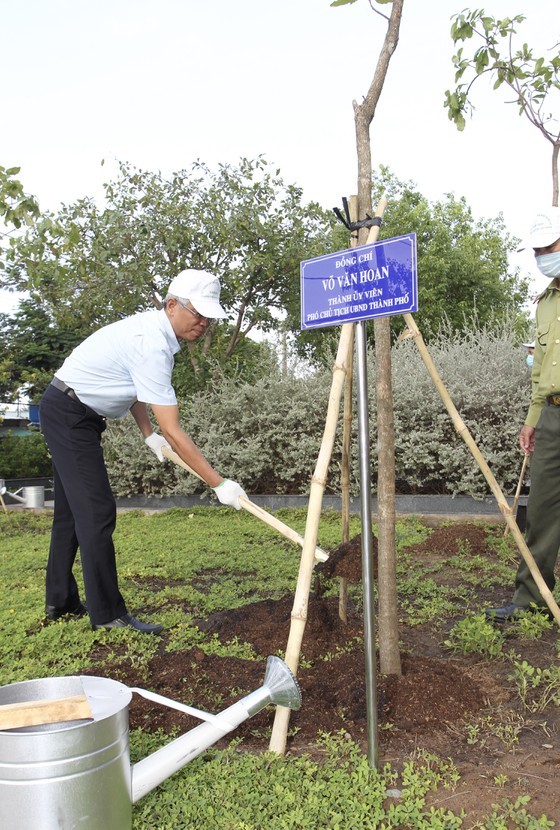A city leader is watering tree (Photo: SGGP)