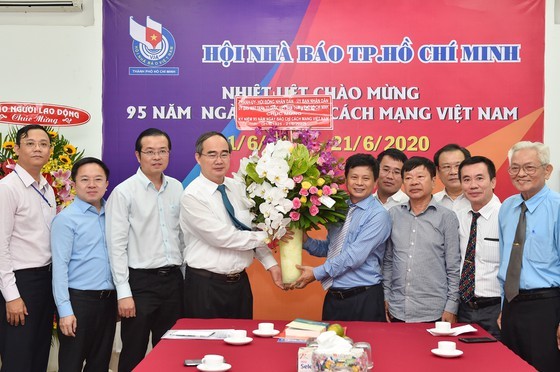 Mr. Nhan gives a bunch of flower to leaders and reporters of the city’s Press Association (Photo: SGGP)