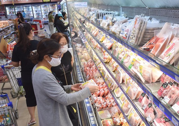 Consumers are choosing pork at a supermarket in HCMC (Photo: SGGP)