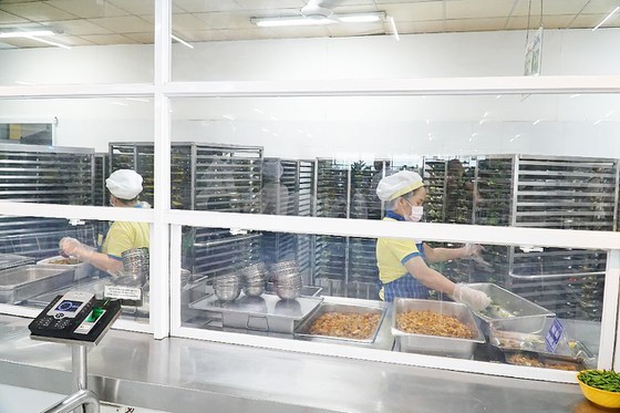 Employees of a school are preparing food for students (Photo: SGGP)