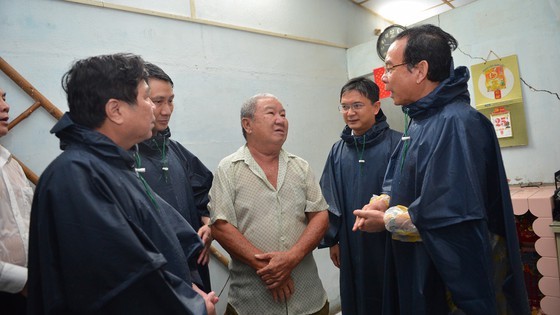 Secretary of Ho Chi Minh City Party Committee Nguyen Van Nen (R) and Chairman of HCMC People's Committee Nguyen Thanh Phong (L) visit people in flood hit areas in Thu Duc District (Photo: SGGP)