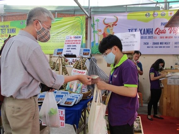 A customer buys banh chung at a fair in HCM City. (Photo: nld.com.vn)